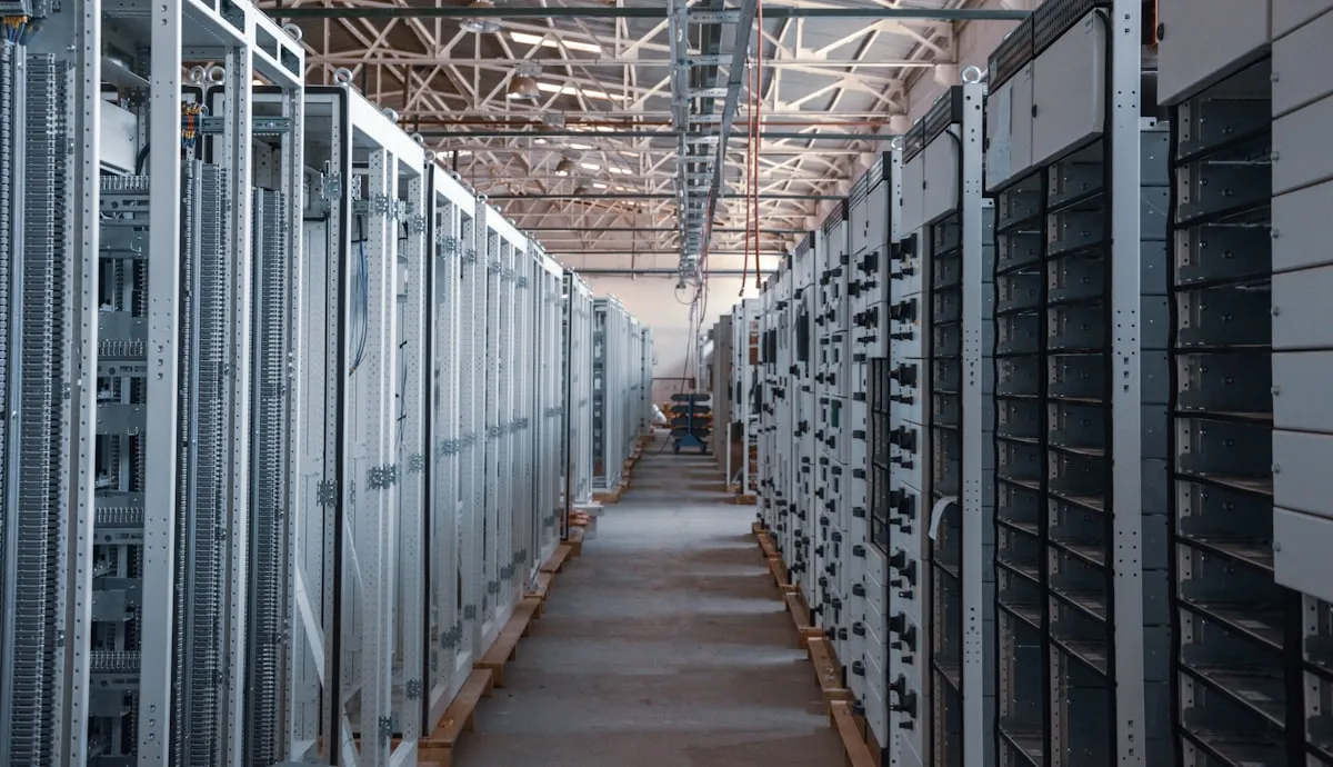 An aisle between long rows of orderly metal equipment cabinets.