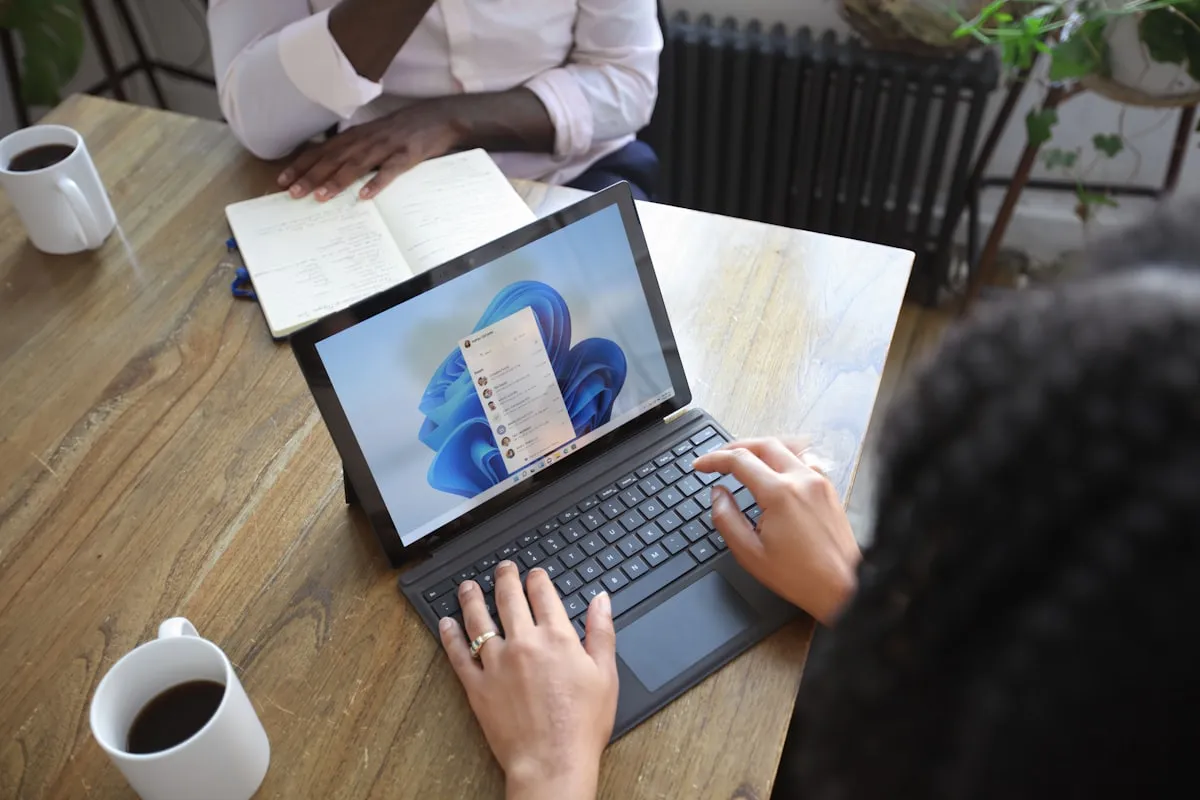 Two people at a table working through notes and a laptop together.