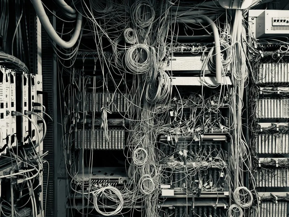 A dense tangle of network cabling filling a communications rack.